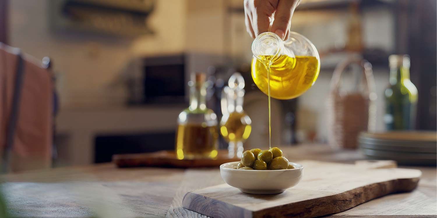 Olive oil being poured over olives