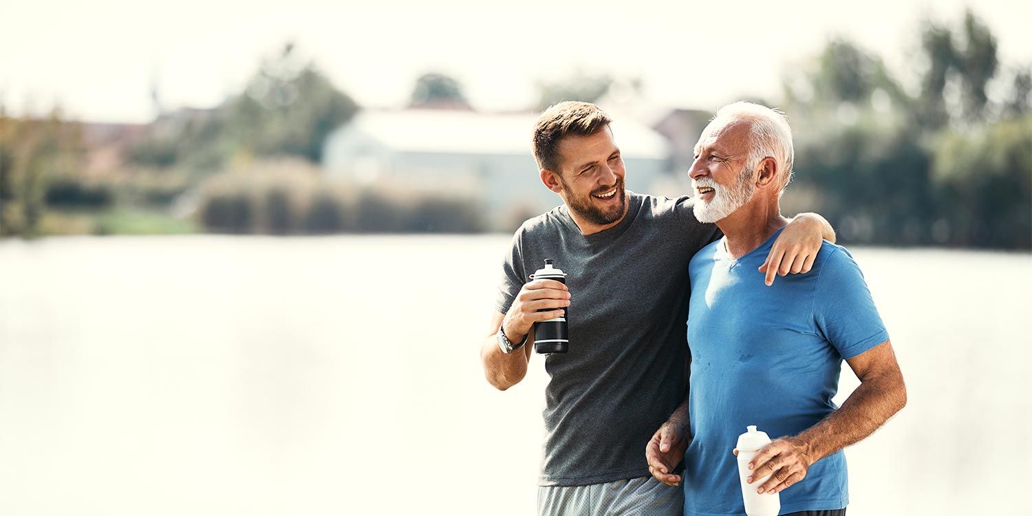 Two adult men, father and son, are outside exercising