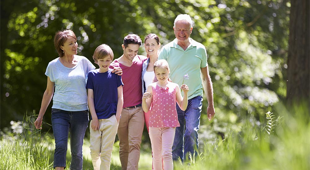 Glad familj är ute och promenerar i naturen