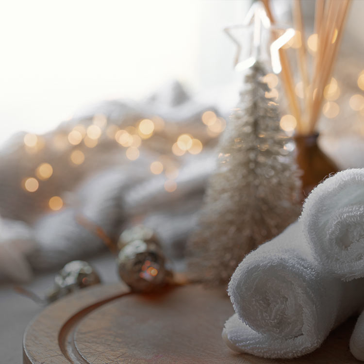 Towels rolled up in a spa setting with Christmas decorations