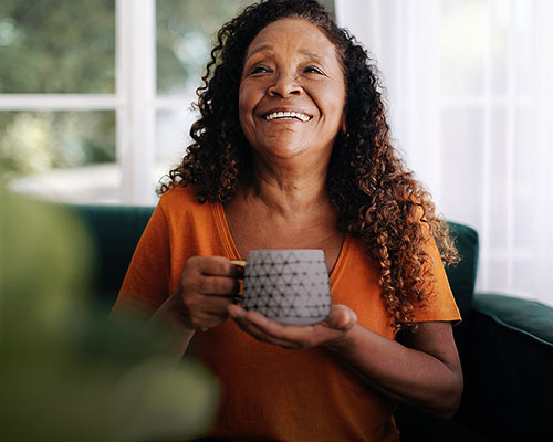 Happy and laughing woman with a teacup in her hand
