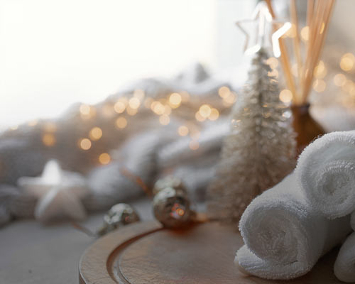 Towels rolled up in a spa setting with Christmas decorations